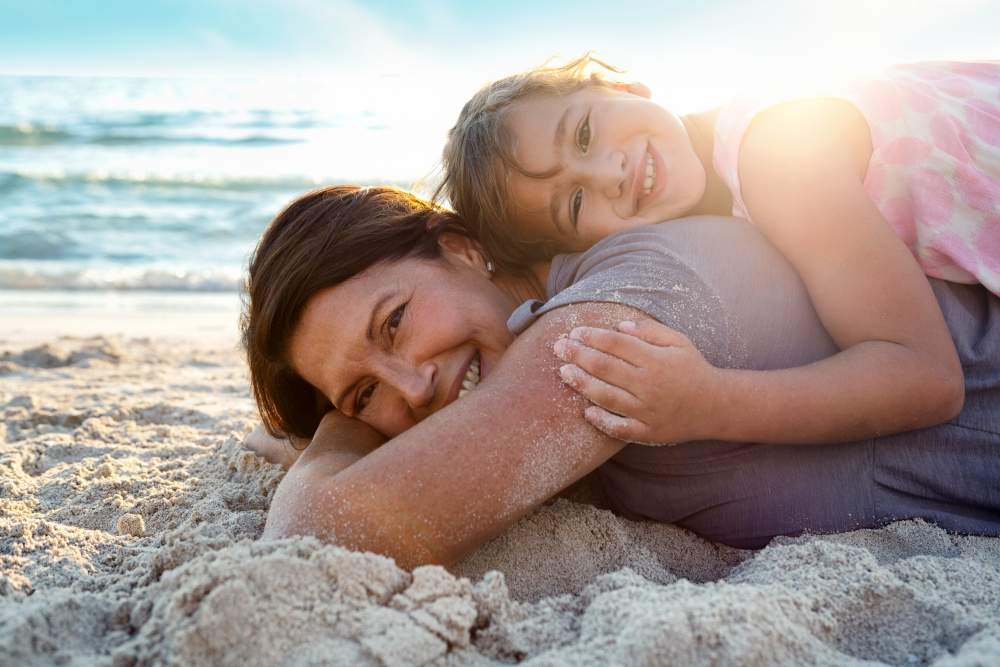 Understanding, Treating and Travelling with Eczema: Grandmother and daughter laying on the beach